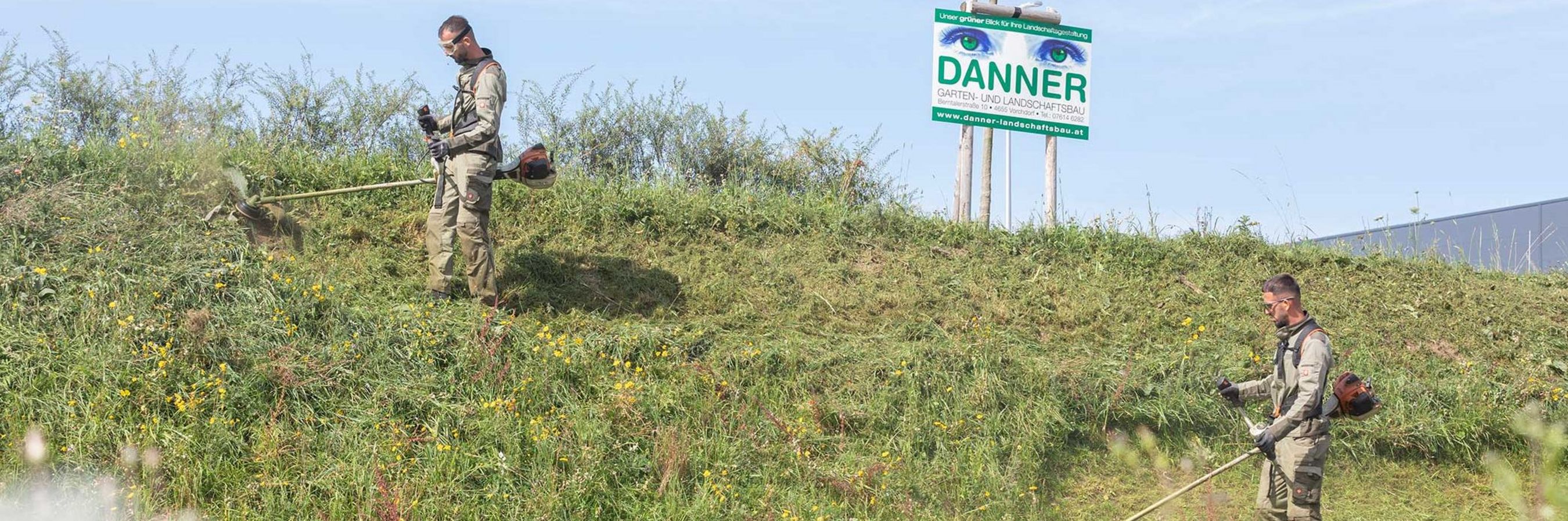 2 Mitarbeiter von Danner bei Mährarbeiten an einer Böschung