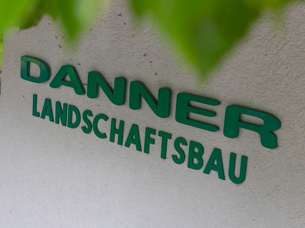 Firmenwortlaut Danner Landschaftsbau in Grün.
